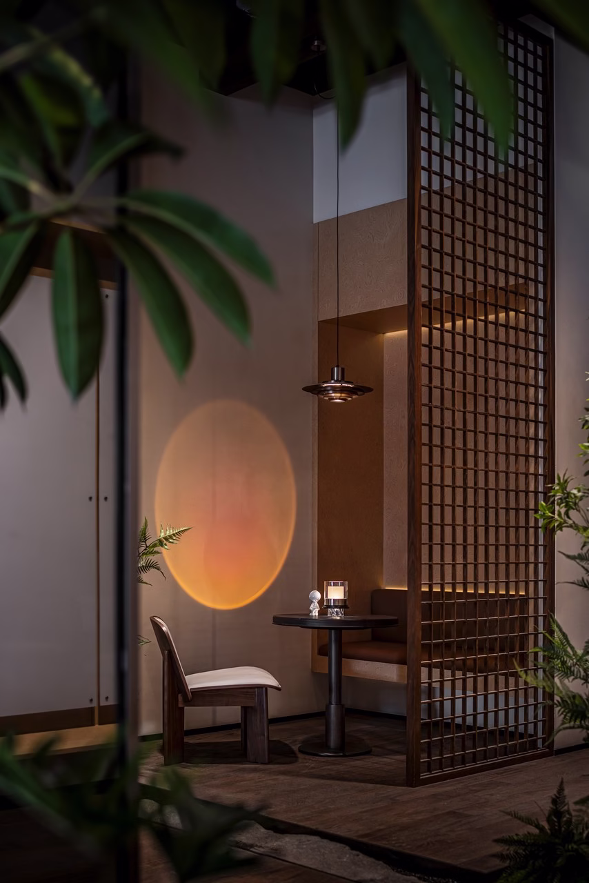 Nowoczesne wnętrze z drewnianą kratą, minimalistycznym stołem i krzesłem.