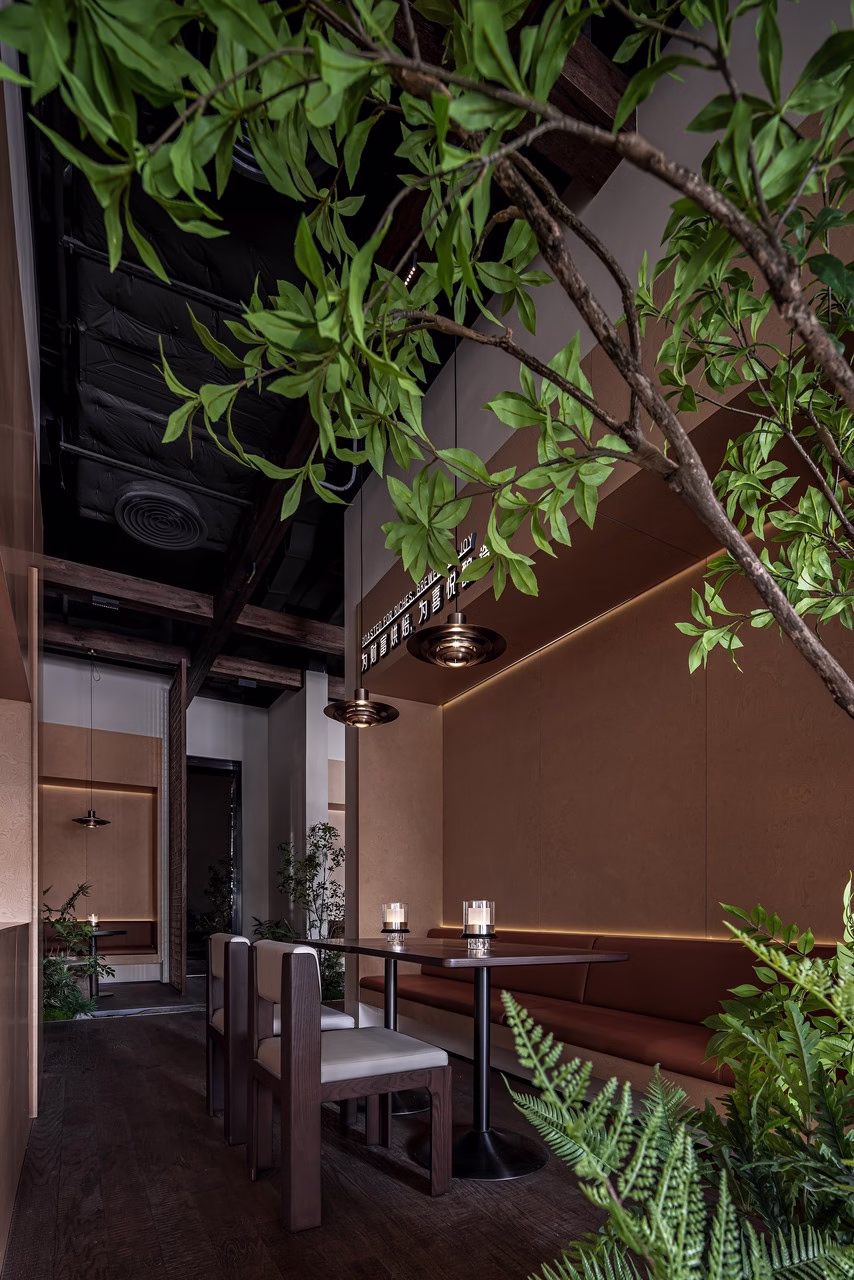 Nowoczesne wnętrze restauracji z drewnianymi meblami i roślinnymi dekoracjami.