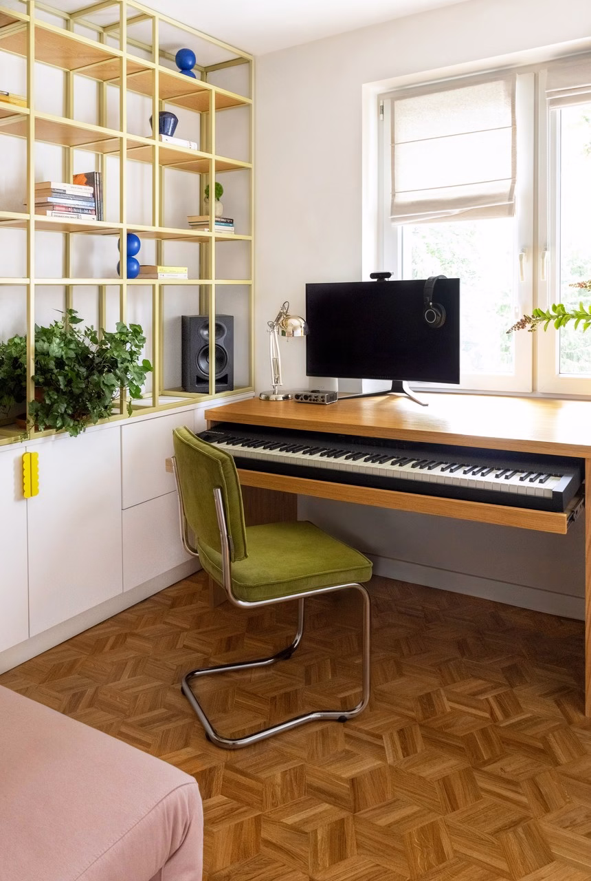 Nowoczesne biuro domowe z fortepianem, zielonym krzesłem i drewnianą podłogą.